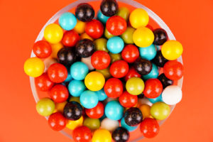Colorful dragee candies close up on orange background