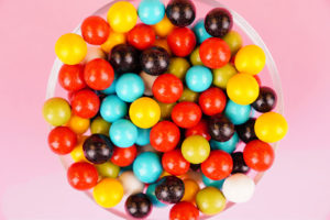 Colorful round candies close up on pink