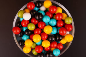 Multicolored round candies close up on black