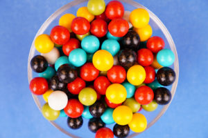 Multicolored round candies close up on blue