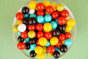 Multicolored round candies close up on green