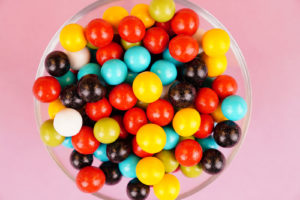 Multicolored round candies close up on pink