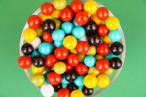 Multicolored round candies close up over green
