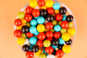 Multicolored round candies close up over orange