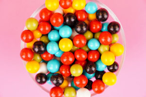 Multicolored round candies close up over pink
