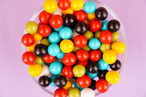 Multicolored round candies close up over purple