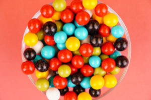 Multicolored round candies close up over red